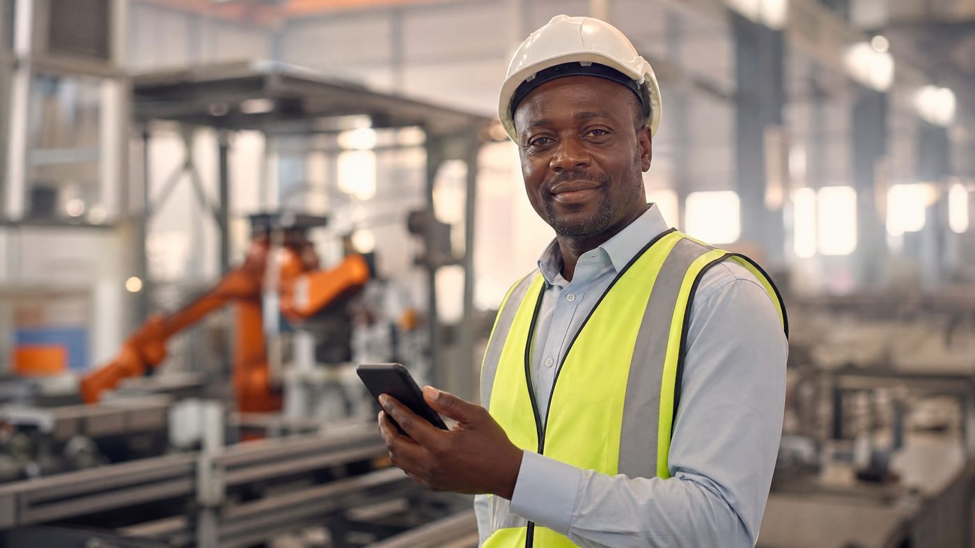 Foreign engineer at a Chinese manufacturing facility checking his salary on his phone
